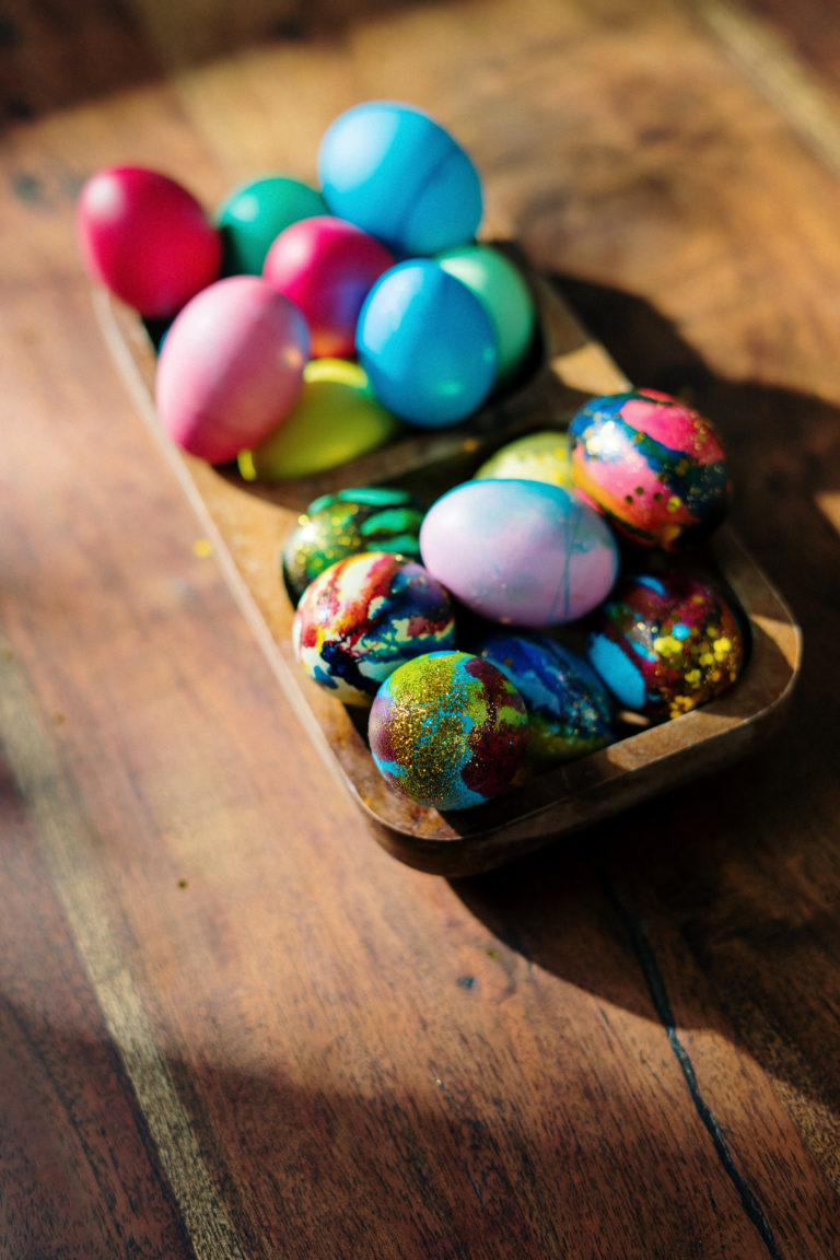 Assorted easter eggs on brown wooden tray